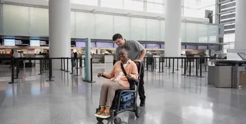 Woman in a wheelchair assisted by staff